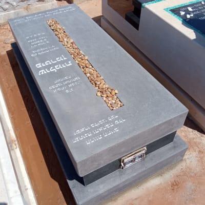 מצבה אפורה עם אבנים קטנות במרכז