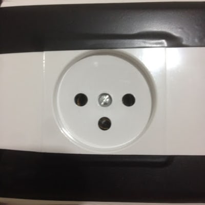 שקע חשמלי עם שלושה חורים על קיר