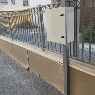 ארון חשמל מותקן על גדר מתכת