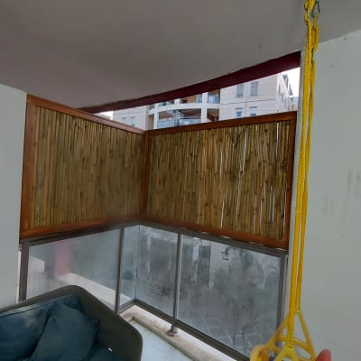 גדר במבוק על מרפסת עם חבלים צהובים תלויים