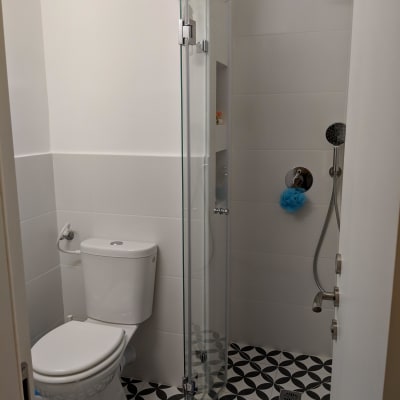 מקלחון זכוכית עם ראש מקלחת עגול ואריחים מעוצבים