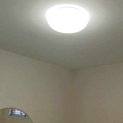 מנורת תקרה עגולה דולקת על תקרה לבנה