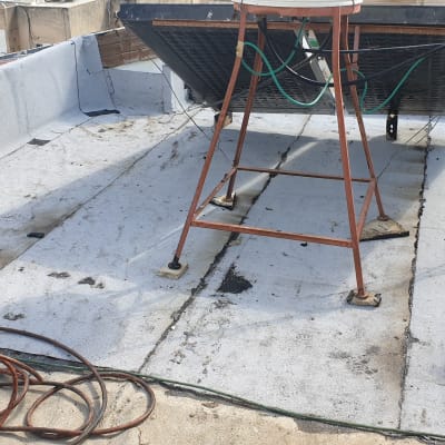 גג עם יריעות איטום, צינורות ומתקן מתכת