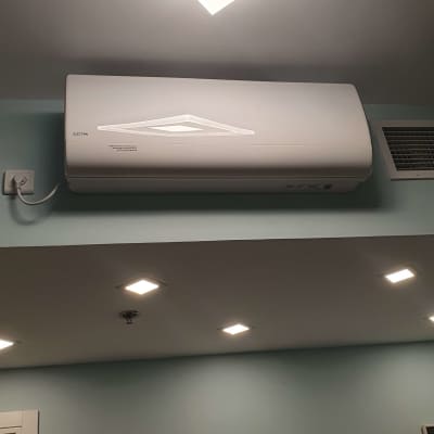 מזגן קיר לבן מותקן על קיר עם שקע חשמל