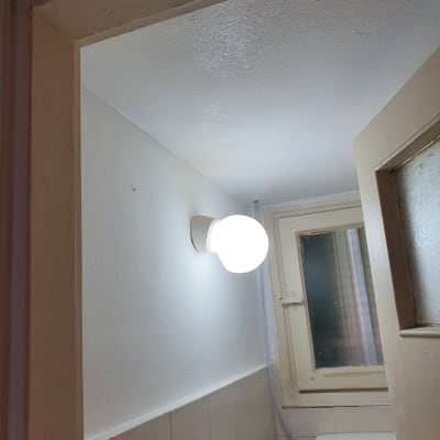 קיר צבוע בלבן עם מנורה דולקת