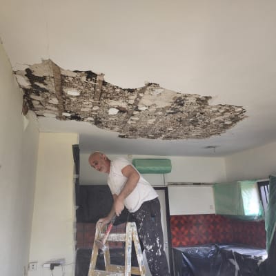 תיקון תקרת גבס פגומה עם סולם וכלים