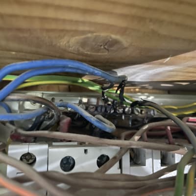 חוטי חשמל צבעוניים מחוברים ללוח חשמל מעץ