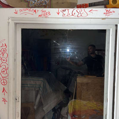 חלון זכוכית עם השתקפות של אדם וחפצים בחדר.