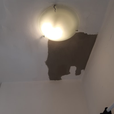 תיקון תקרה עם טיח ליד מנורה עגולה