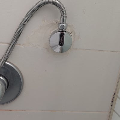 צינור מתכת מחובר לקיר בחדר אמבטיה