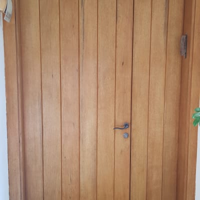 Wooden door with vertical panels and metal handle