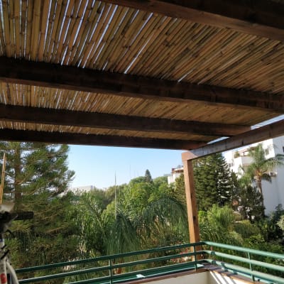 פרגולה מעץ עם קורות במרפסת