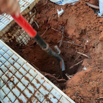 חפירה באדמה עם כלי עבודה אדום