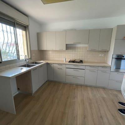 מטבח משופץ עם ארונות חדשים ואדם בודק ארון