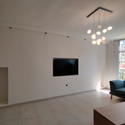 קיר גבס עם טלוויזיה תלויה ומנורות תקרה