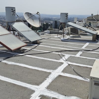 איטום גג עם חומר לבן בין לוחות בטון