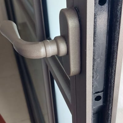 ידית מתכת על תריס חלון זכוכית