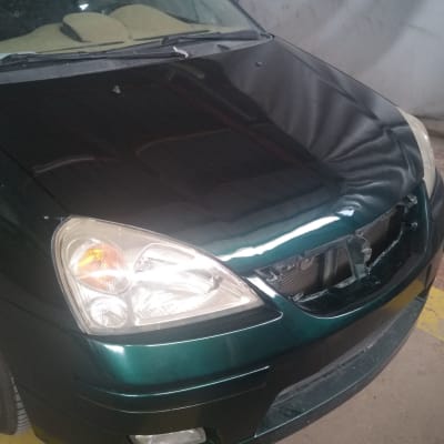 מכונית עם מכסה מנוע פתוח בתיקון פחחות