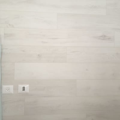 קיר עם חיפוי פרקט בהיר ושקע חשמל