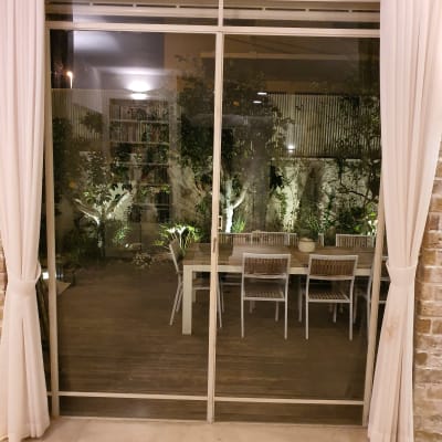 דלת זכוכית גדולה עם וילונות לבנים בצדדים