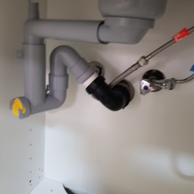 צנרת פלסטיק מתחת לכיור עם ברזים