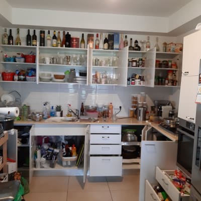 מטבח עם ארונות פתוחים, בקבוקים וכלי מטבח על המדפים