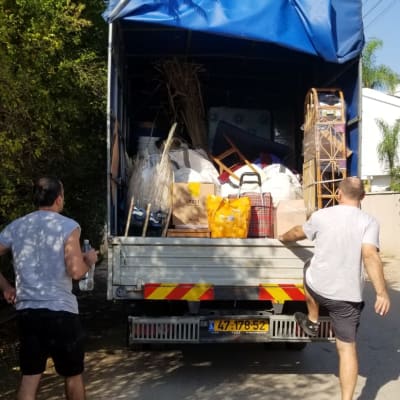 שני אנשים מעמיסים משאית עם חפצים שונים