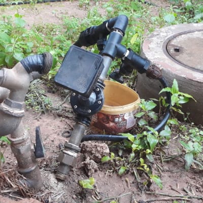 ברזים וצינורות מחוברים עם סרט שחור בגינה