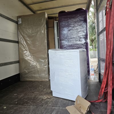 ארגזים וציוד עטופים בניילון בתוך משאית הובלה