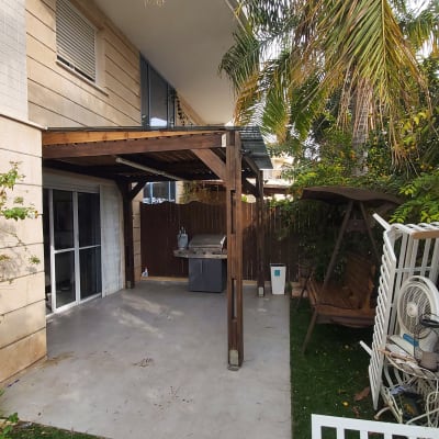 פרגולה מעץ עם גריל גז בחצר הבית