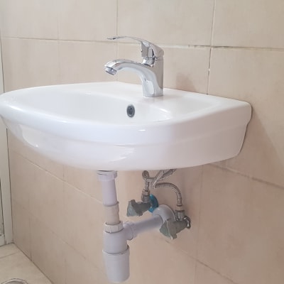 כיור עם ברז וצנרת מתחת