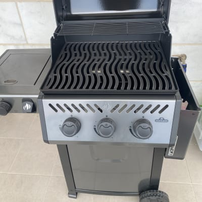 גריל גז עם שלושה כפתורי שליטה ומכסה פתוח