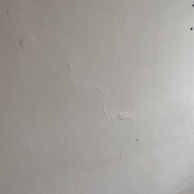 קיר עם סדקים ושקע חשמל