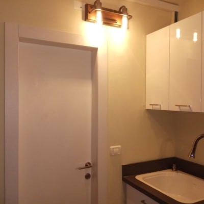 מנורת קיר דולקת מעל דלת לבנה