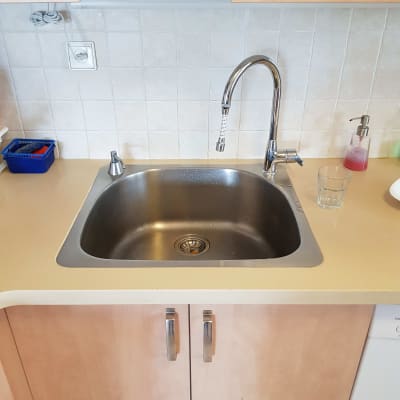 אריחי שיש לבנים על קיר המטבח מעל הכיור