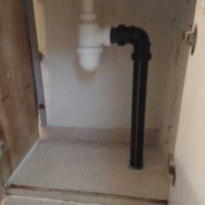 צינור ביוב שחור ולבן מתחת לכיור