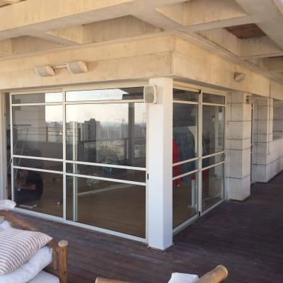 חלונות אלומיניום גדולים במרפסת עם מסגרת לבנה