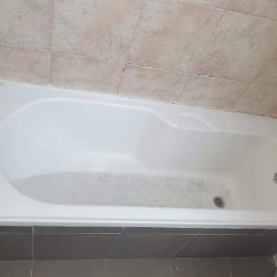 אמבטיה לבנה עם אריחים חומים מסביב