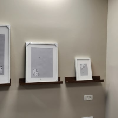 מסגרות תמונה על מדפים מעץ על קיר