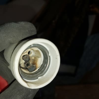 שקע מנורה מוחזק בכפפה שחורה