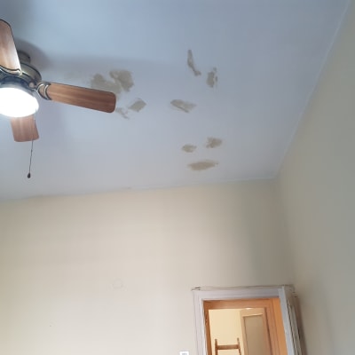 תקרה עם תיקוני צבע וטיח ליד מאוורר תקרה