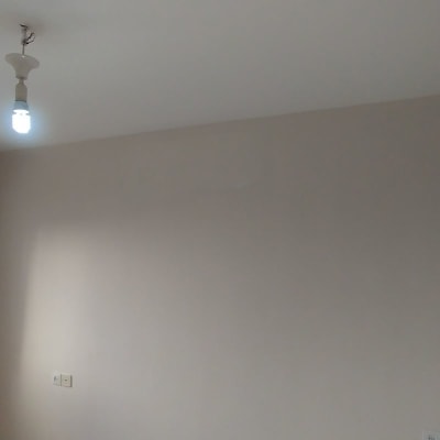 קיר צבוע בצבע בהיר עם חלון וסורג