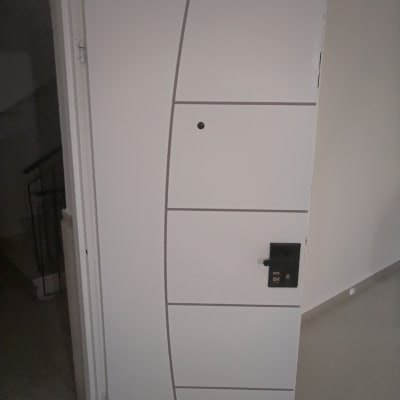 דלת לבנה עם ידית שחורה בתהליך התקנה