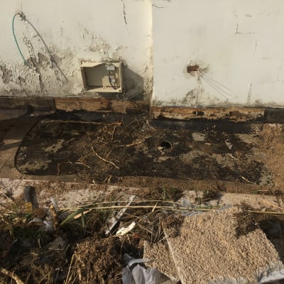 אדם מניח יריעת איטום על הקרקע ליד קיר