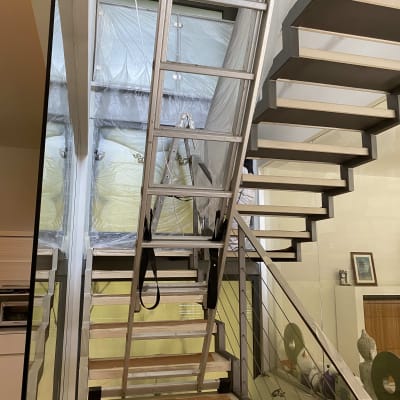 סולם מתכת ליד מדרגות מכוסות בניילון לצביעה