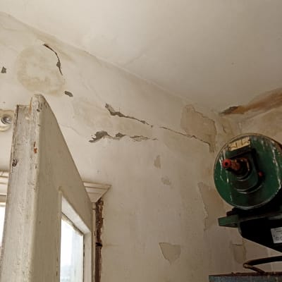 קיר מתקלף עם סדקים ותקרה מתקלפת