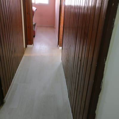 רצפת פרקט בהירה במסדרון עם קירות עץ כהים