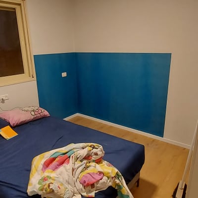 קיר צבוע בחצי כחול וחצי לבן בחדר שינה