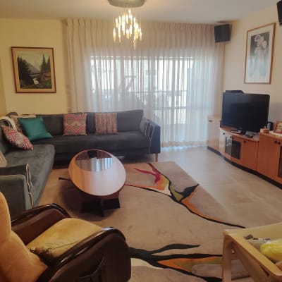 וילון לבן שקוף תלוי על חלון גדול בסלון