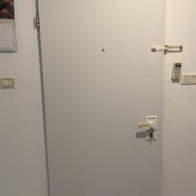 דלת לבנה עם מנעול ובריח על הקיר